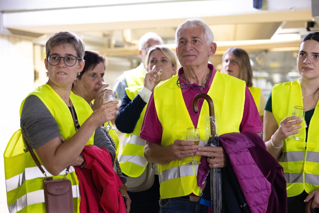 Mehrere Volksbank-Mitglieder genießen eine Probe in der Brauereihalle von Licher.