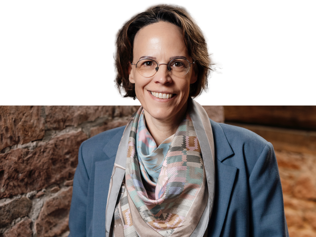 Ein Vorstandsmitglied der Volksbank Mittelhessen steht im Business‑Anzug vor einem modernen Hintergrund.