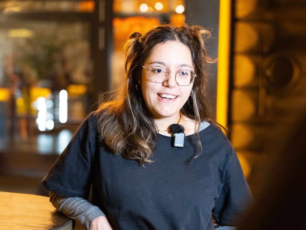 Ein Volksbank-Mitglied lehnt lachend an einem Hochtisch im Timberjacks.